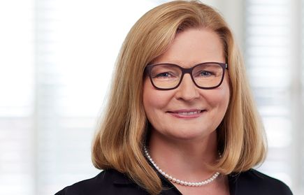 Lächelnde Frau mit Brille und Perlenkette, Mitglied des Kuratoriums